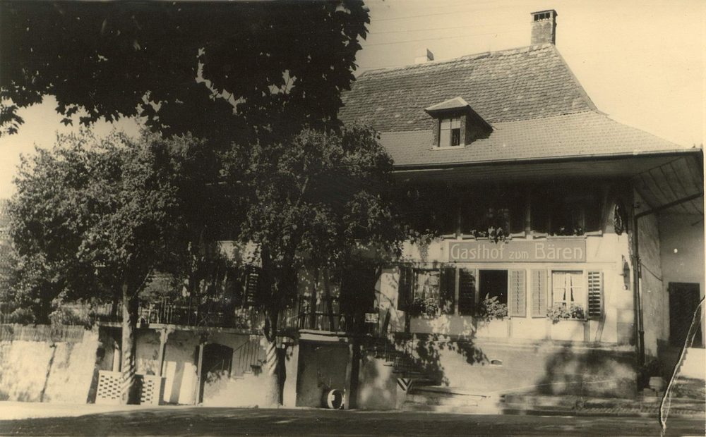 Historische Aufnahme des Gasthauses zum Bären in Konolfingen mit grossem Baum davor.