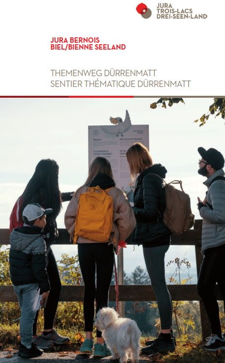 Eine Wandergruppe steht vor einer Informationstafel eines Themenwegs.