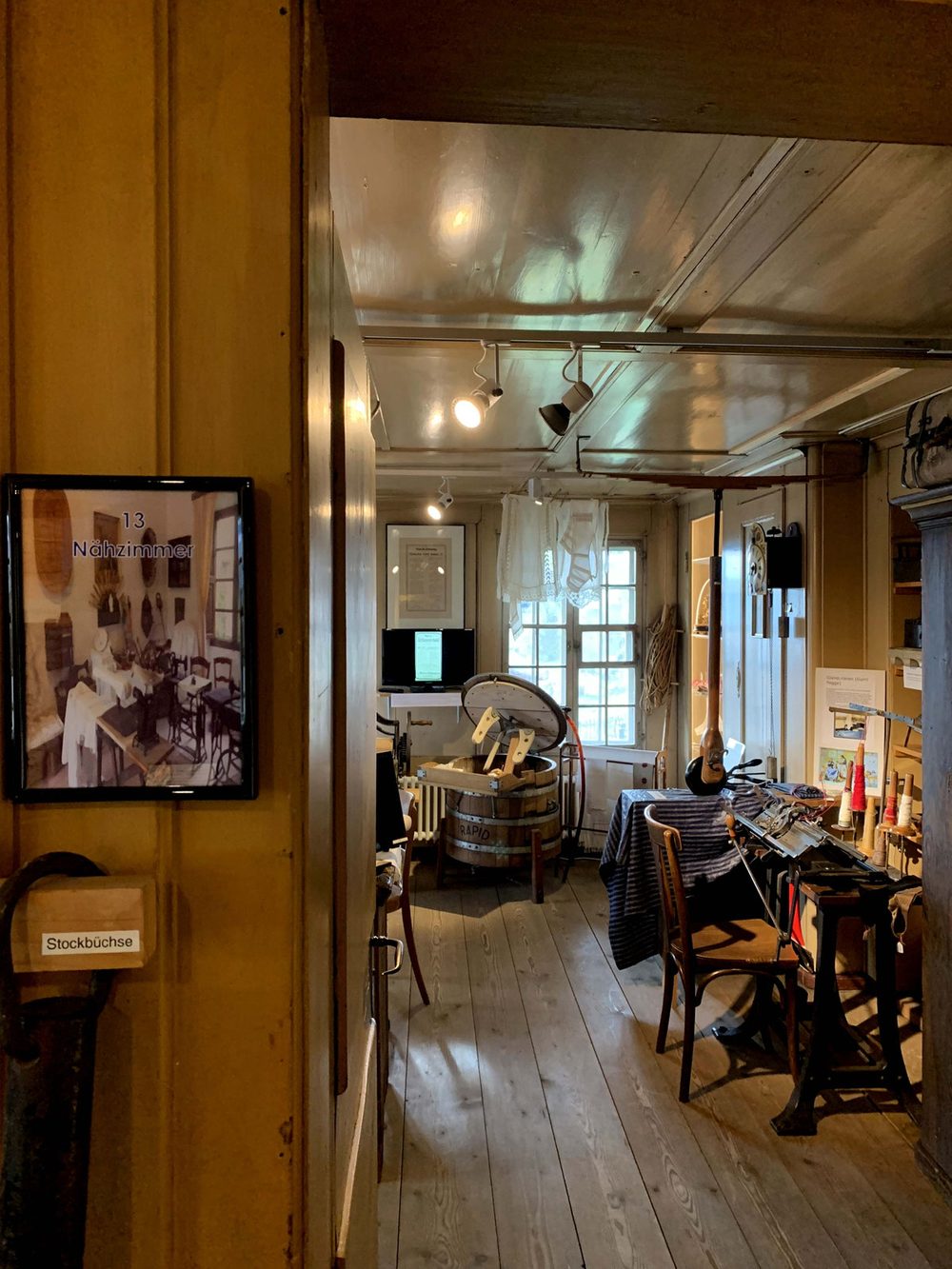 Das Nähzimmer mit Nähmaschine, Bügeleisen und Textilien.